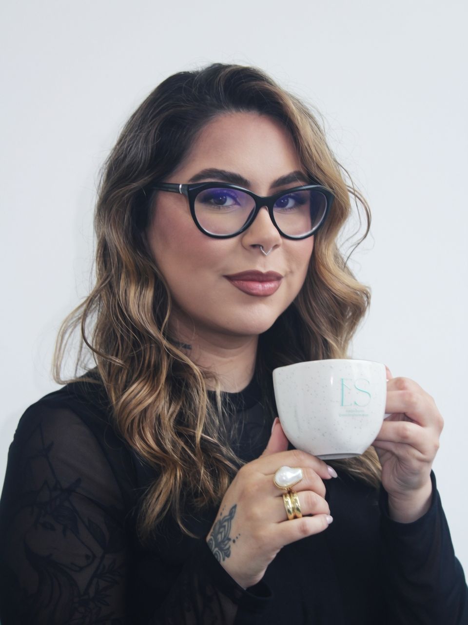 Evelyn Soares segura uma caneca com o monograma ES da marca.